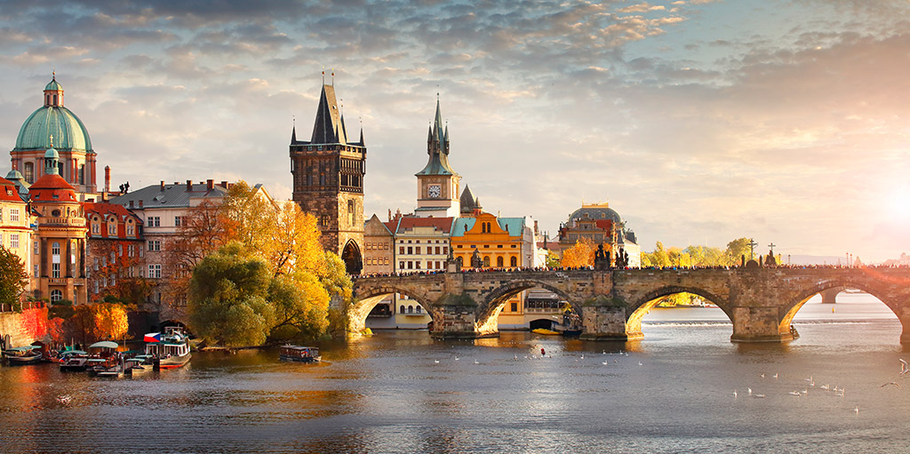 Die berühmte Karlsbrücke in Prag überspannt die Moldau, gesäumt von historischen Gebäuden und Türmen. Im Hintergrund sind die beeindruckenden Türme der Prager Burg und der St.-Nikolaus-Kirche zu sehen. Die Szene wird von einem warmen, goldenen Licht bei Sonnenaufgang oder Sonnenuntergang beleuchtet und fängt die romantische Atmosphäre der tschechischen Hauptstadt ein. (Booking) Die berühmte Karlsbrücke in Prag überspannt die Moldau, gesäumt von historischen Gebäuden und Türmen. Im Hintergrund sind die beeindruckenden Türme der Prager Burg und der St.-Nikolaus-Kirche zu sehen. Die Szene wird von einem warmen, goldenen Licht bei Sonnenaufgang oder Sonnenuntergang beleuchtet und fängt die romantische Atmosphäre der tschechischen Hauptstadt ein. (Booking)
